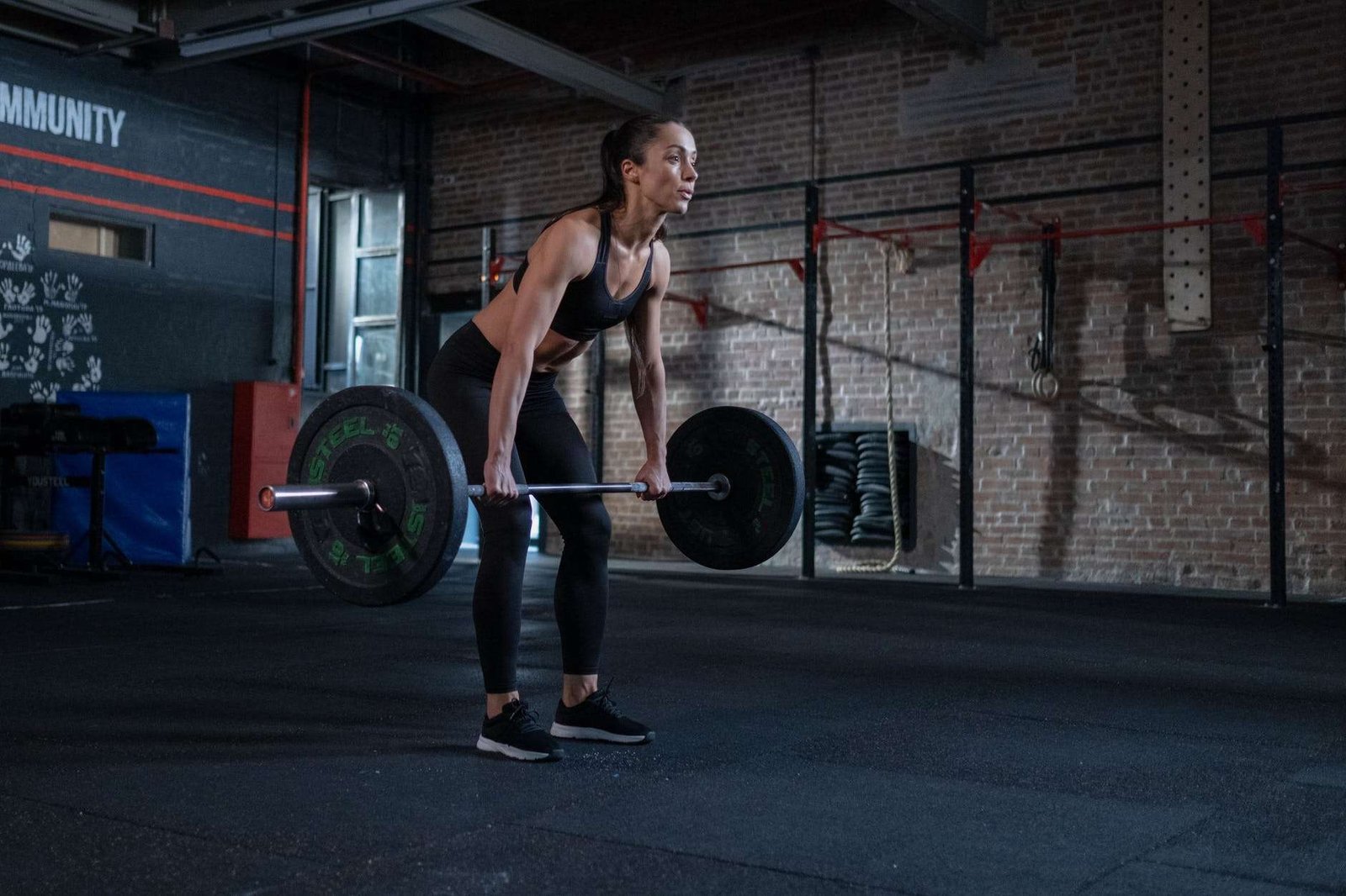 woman in black sportswear lifting a barbell